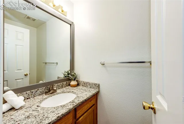 a bathroom with a granite countertop sink and a mirror