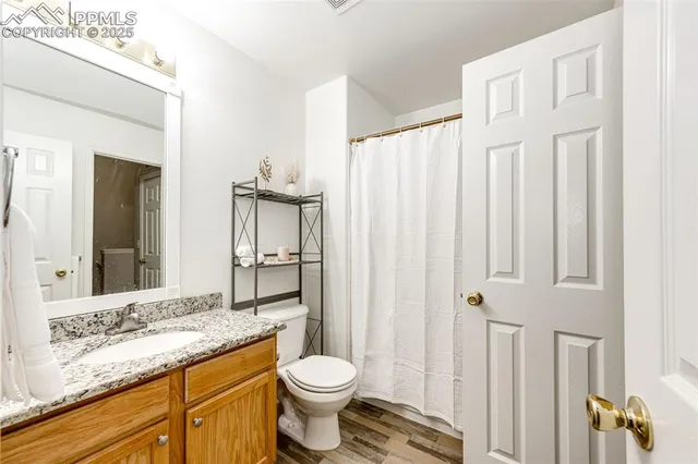 a bathroom with a granite countertop sink toilet and shower
