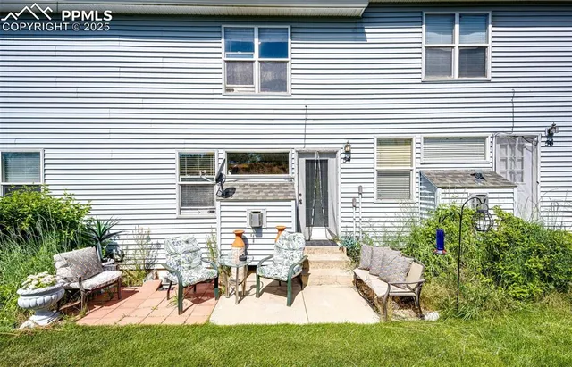 a view of a house with backyard and sitting area