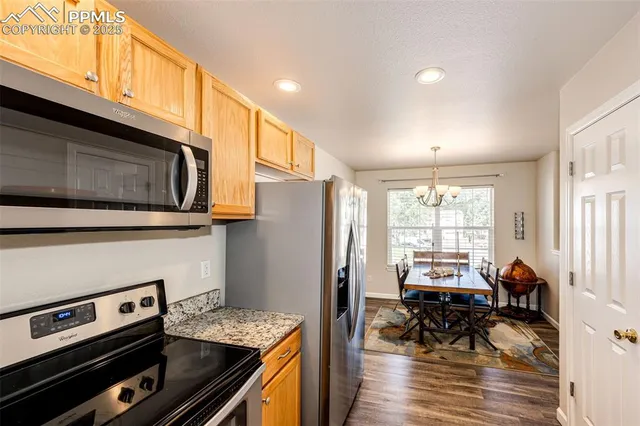 a kitchen with stainless steel appliances kitchen island granite countertop a stove and a refrigerator
