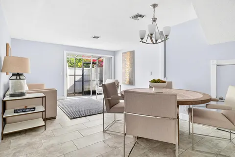 a living room with furniture a chandelier and a table