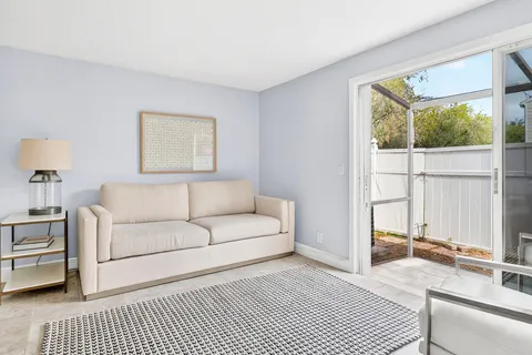a living room with furniture a large window and a rug