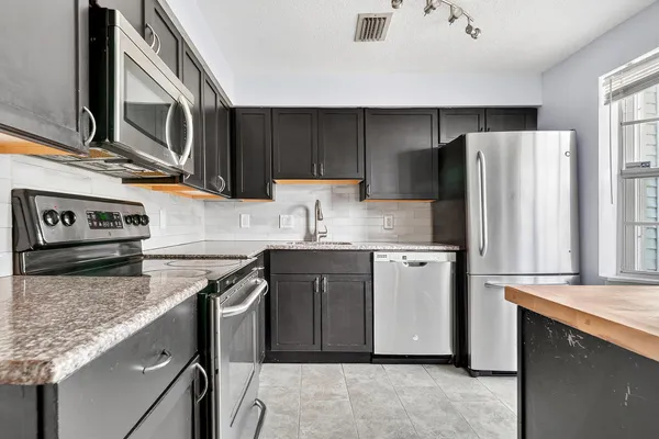 a kitchen with stainless steel appliances granite countertop a sink stove and refrigerator