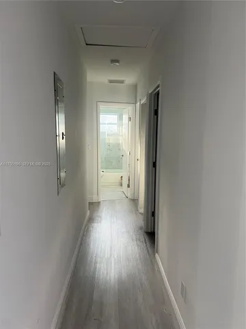 a view of a hallway with wooden floor and furniture