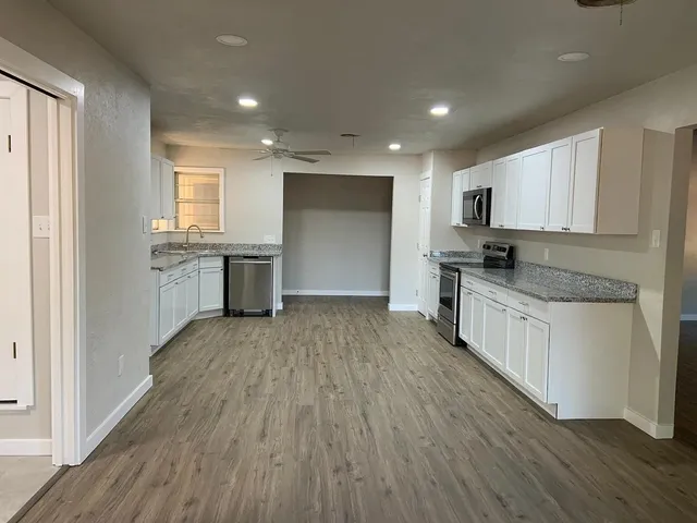 a kitchen with a sink a stove a refrigerator and cabinets