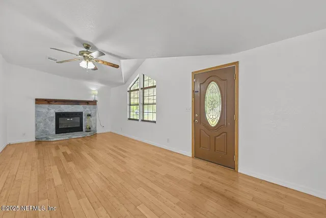 a view of empty room with fireplace and fan