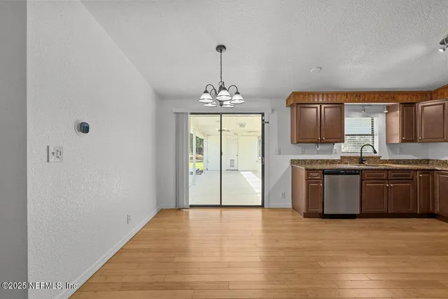 a kitchen with kitchen island granite countertop a stove top oven a sink and a chandelier