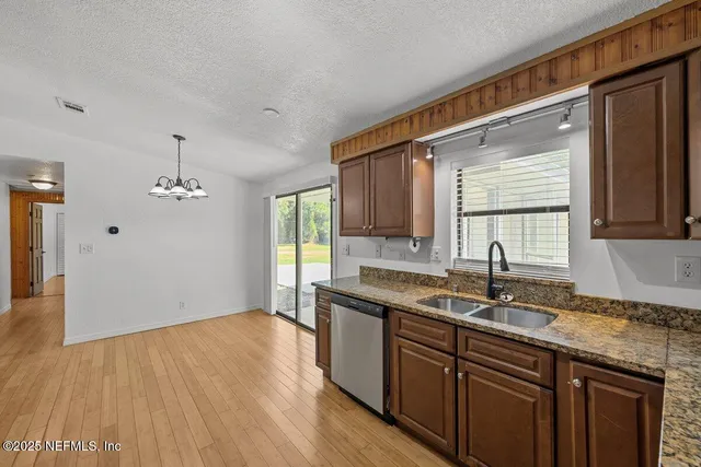 a kitchen with a sink and wooden floor