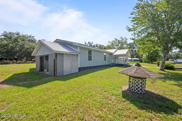 a view of a house with backyard and sitting area