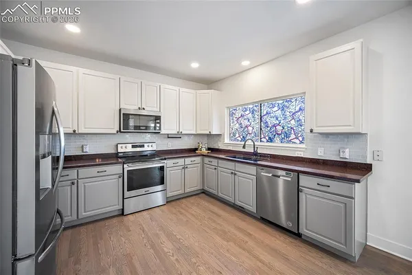 a kitchen with granite countertop white cabinets and white appliances