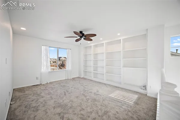 a view of empty room with a ceiling fan and window