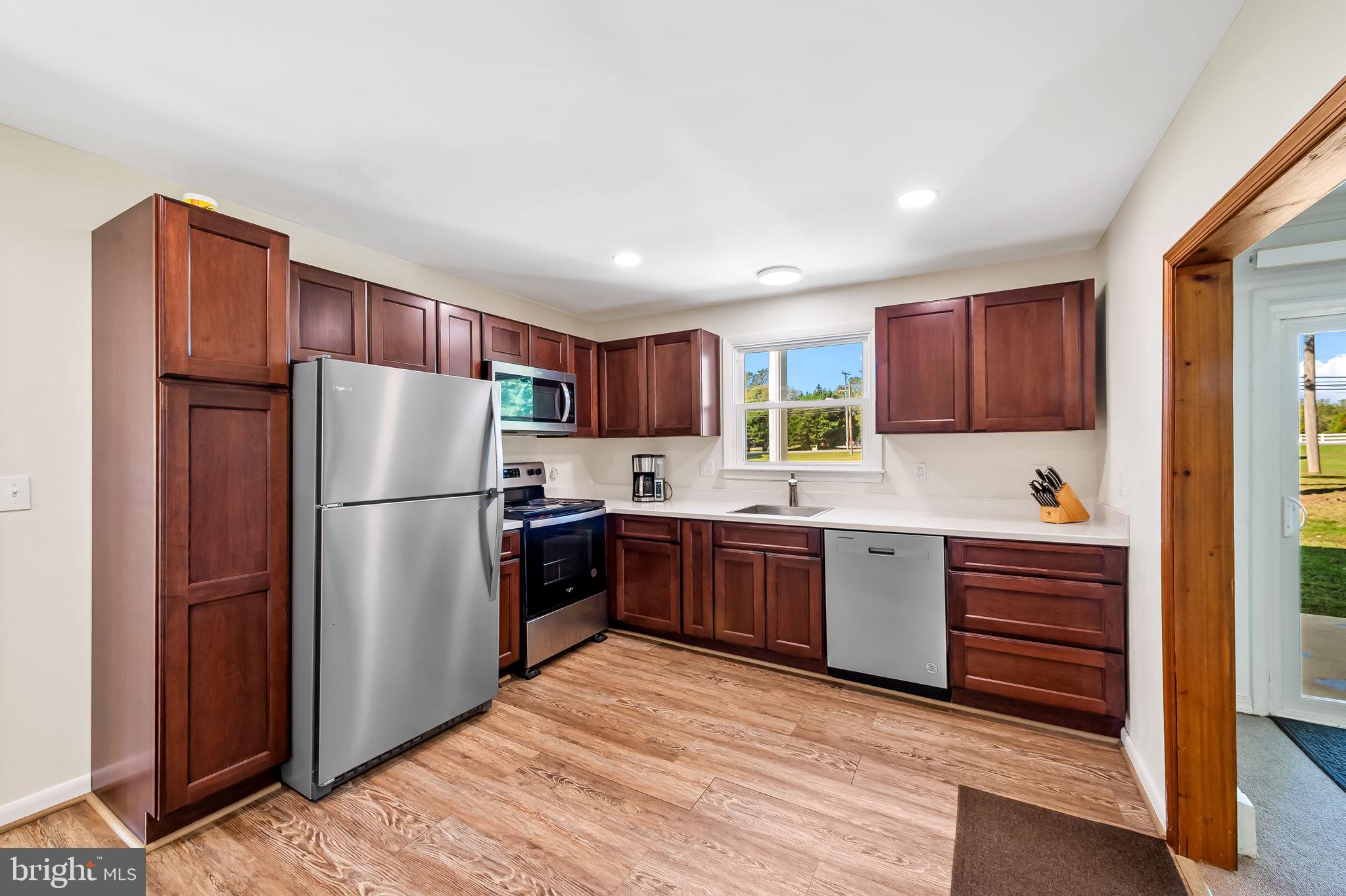315 Brick Church Road Davidsonville, MD 21035 - Photo 11 of 45 a kitchen with a refrigerator sink and wooden cabinets