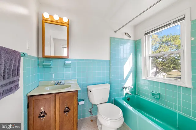 a bathroom with a sink a toilet a mirror and bathtub