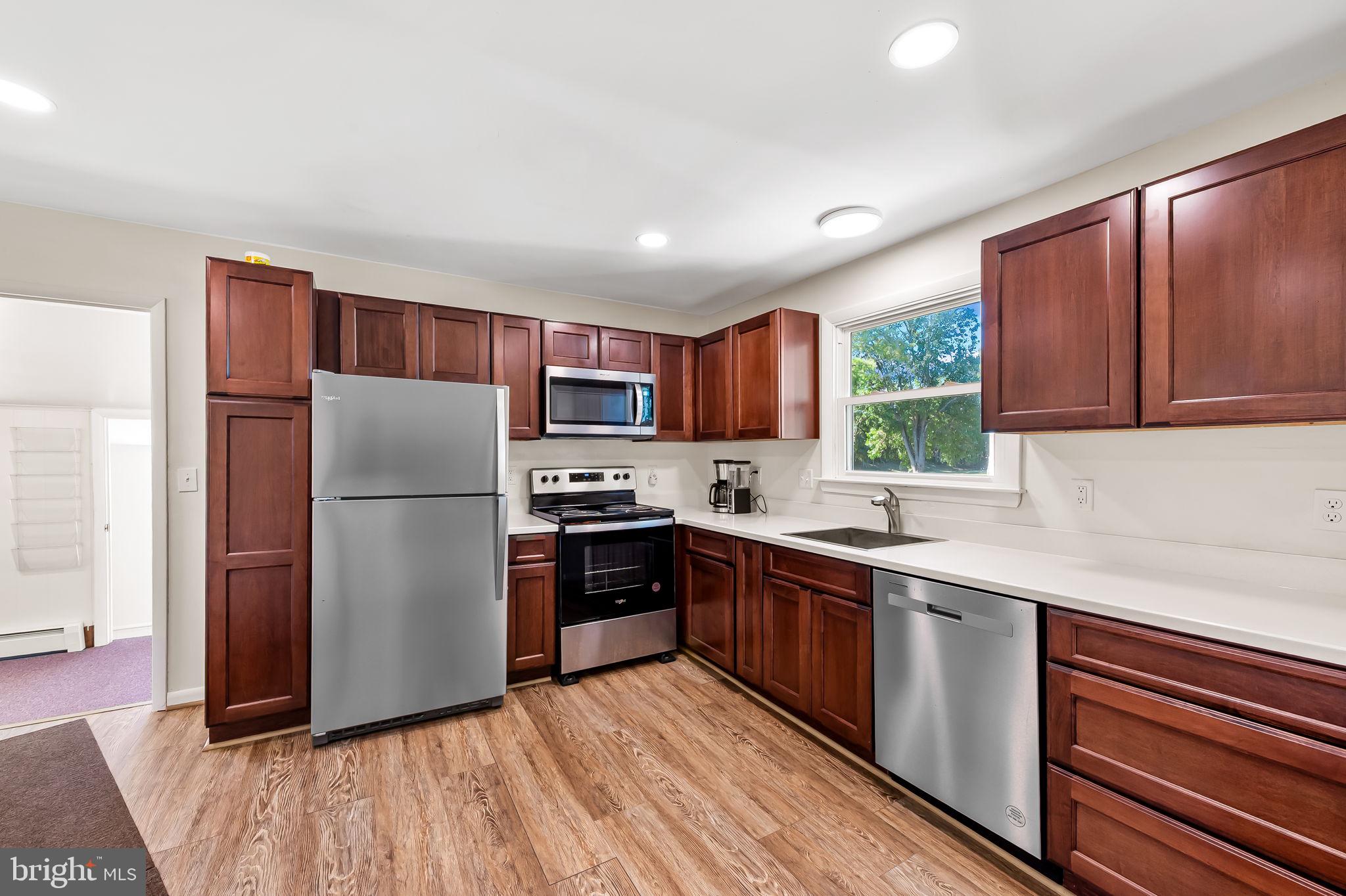 315 Brick Church Road Davidsonville, MD 21035 - Photo 10 of 45 a kitchen with a refrigerator a sink dishwasher with a dining table and wooden floor