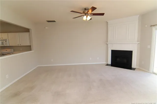an empty room with fireplace and wooden floor