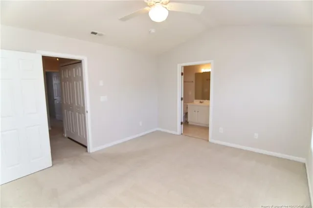 an empty room with closet and a chandelier fan