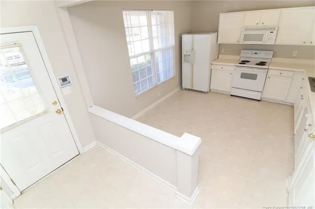 a kitchen with white cabinets and white appliances