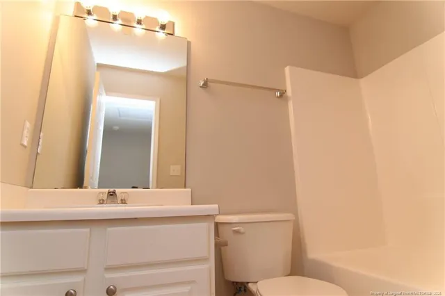 a bathroom with a sink mirror vanity and toilet