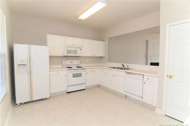 a kitchen with white cabinets sink and white appliances
