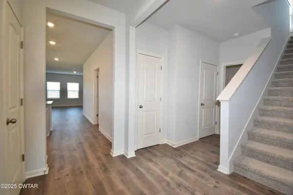 a view of a hallway with wooden floor and staircase