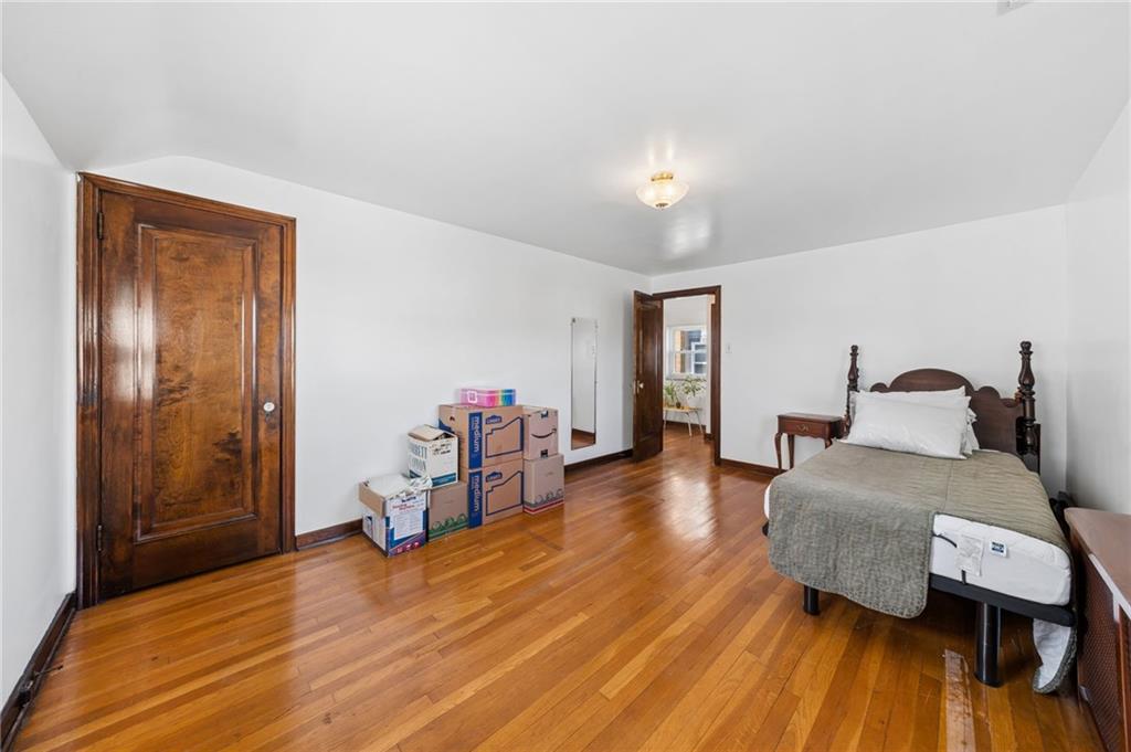 317 Raymond Street Pittsburgh, PA 15218 - Photo 20 of 36 a bedroom with furniture and a wooden floor