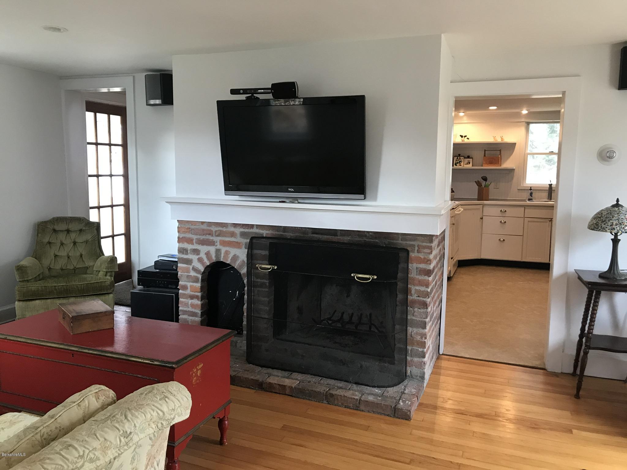 1679 Swamp Road Richmond, MA 01254 - Photo 12 of 33 a living room with furniture a flat screen tv and a fireplace