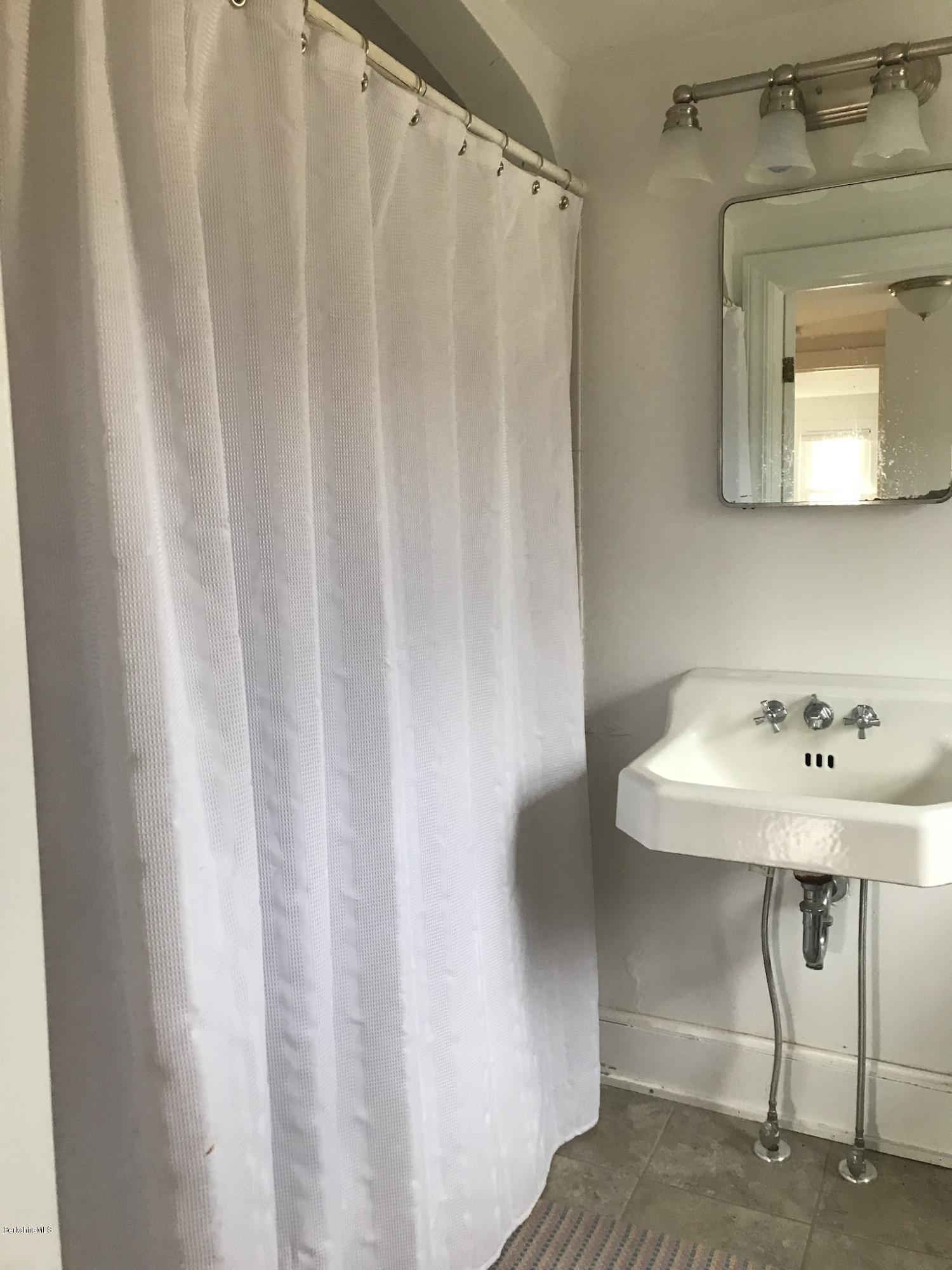 1679 Swamp Road Richmond, MA 01254 - Photo 20 of 33 a bathroom with a sink a mirror and a shower curtain