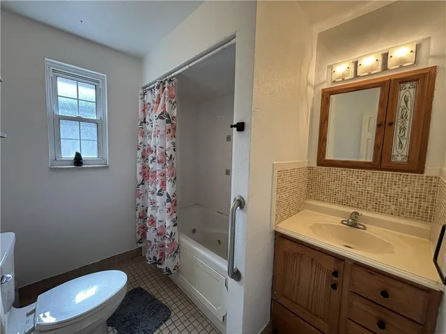 a bathroom with a toilet and shower curtain