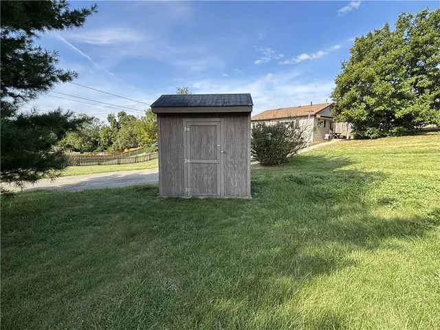 a view of a house with a big yard and large trees