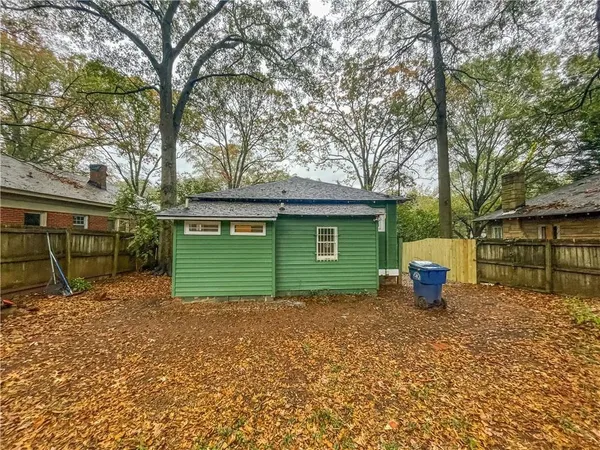 a view of a house with a backyard and a tree