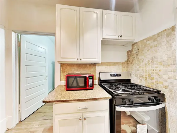 a kitchen with granite countertop stove and cabinets