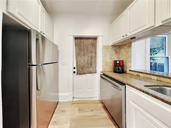 a kitchen with stainless steel appliances granite countertop a refrigerator and a sink