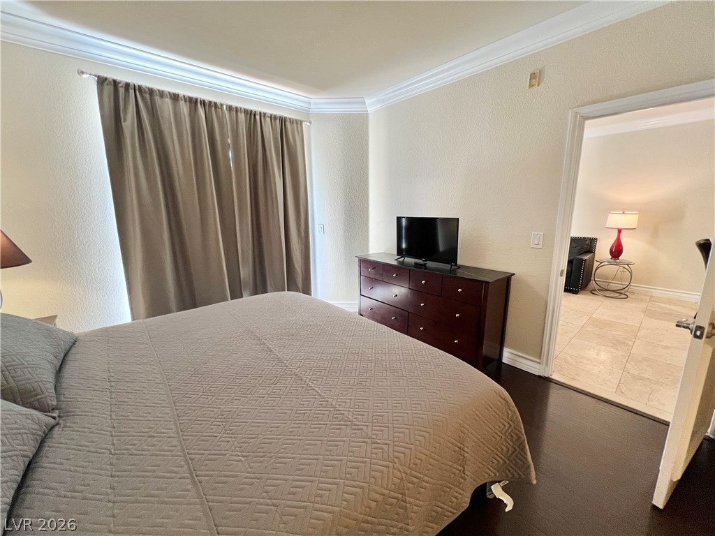 270 East Flamingo Road, Unit 313 Las Vegas, NV 89169 - Photo 10 of 27 Rich hardwood floors create a welcoming path from this serene bedroom to an adjacent living space.