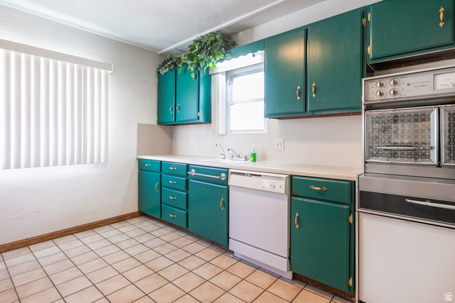 59 East Pinehurst Street Tooele, UT 84074 - Photo 8 of 22 Kitchen featuring green cabinetry with gold-toned hardware, a white dishwasher, and a built-in double oven