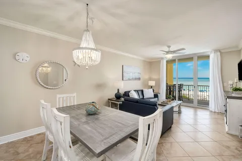a kitchen island with granite countertop a stove a sink a dining table and chairs