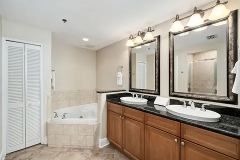 a bathroom with a tub double sink mirror and