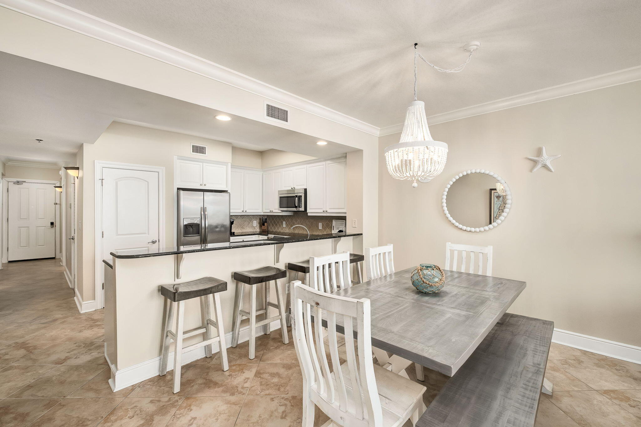 1150 Santa Rosa Boulevard, Unit 305 Fort Walton Beach, FL 32548 - Photo 17 of 43 a kitchen with stainless steel appliances kitchen island granite countertop a table chairs and a refrigerator