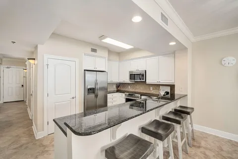 a kitchen with stainless steel appliances granite countertop a sink refrigerator and cabinets