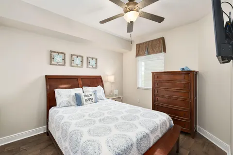 a bedroom with a bed and a flat tv screen on dresser