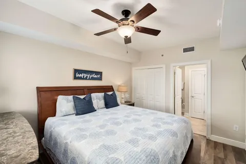 a bedroom with a large bed and a ceiling fan