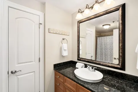 a bathroom with a granite countertop sink and a mirror