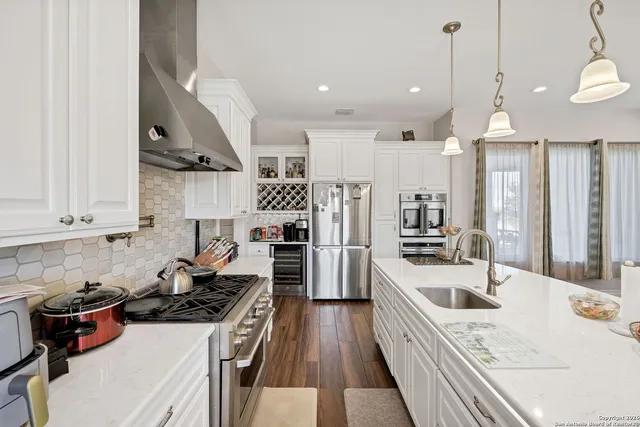 a kitchen with stainless steel appliances a stove a sink a refrigerator and cabinets