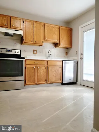 a view of a kitchen with stainless steel appliances granite countertop a stove a sink and a microwave