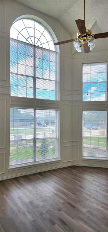 716 Violet Court Mesquite, TX 75150 - Photo 5 of 19 an empty room with wooden floor fan and windows