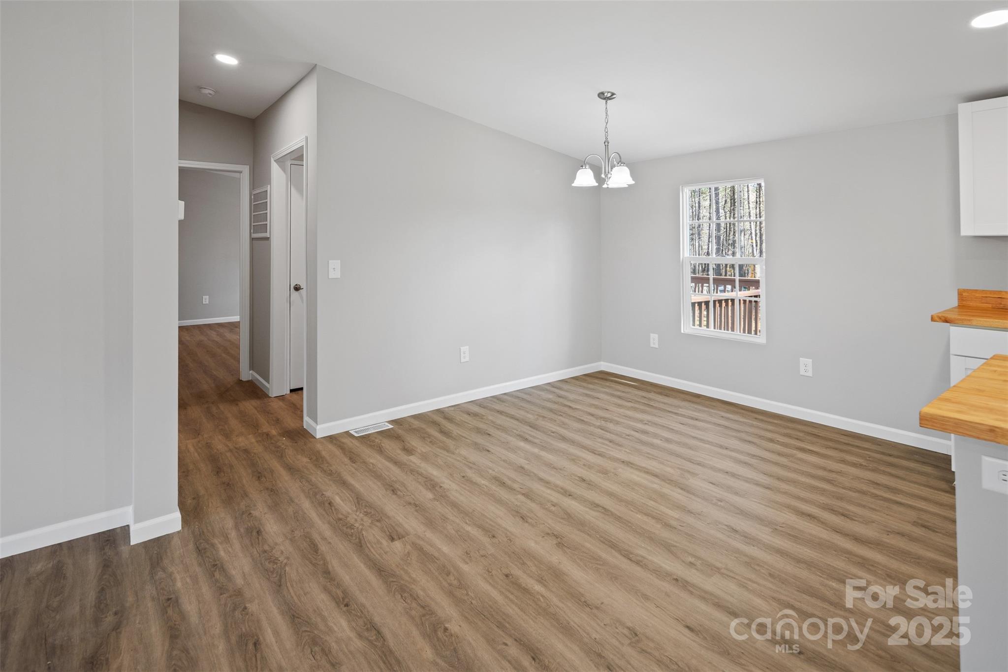 166 Brook Creek Drive Troutman, NC 28166 - Photo 14 of 26 an empty room with wooden floor and windows