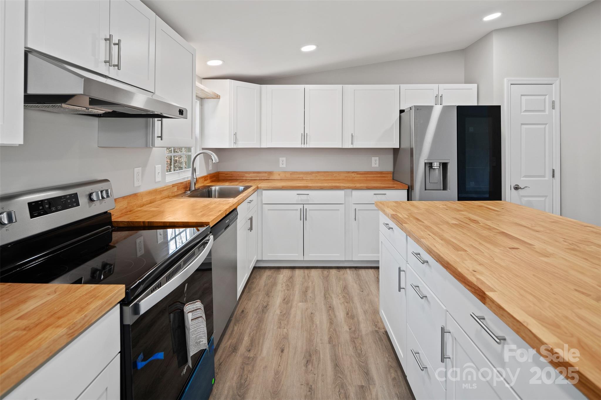 166 Brook Creek Drive Troutman, NC 28166 - Photo 15 of 26 a kitchen with a stove a sink and a refrigerator