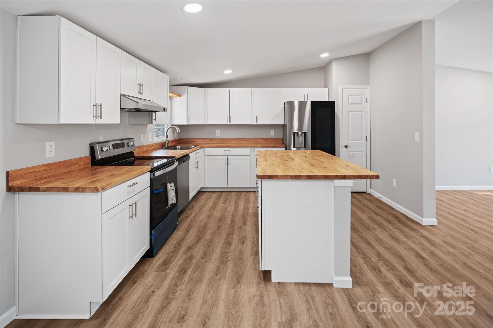 166 Brook Creek Drive Troutman, NC 28166 - Photo 16 of 26 a kitchen with stainless steel appliances granite countertop wooden cabinets a sink a stove a refrigerator and white cabinets