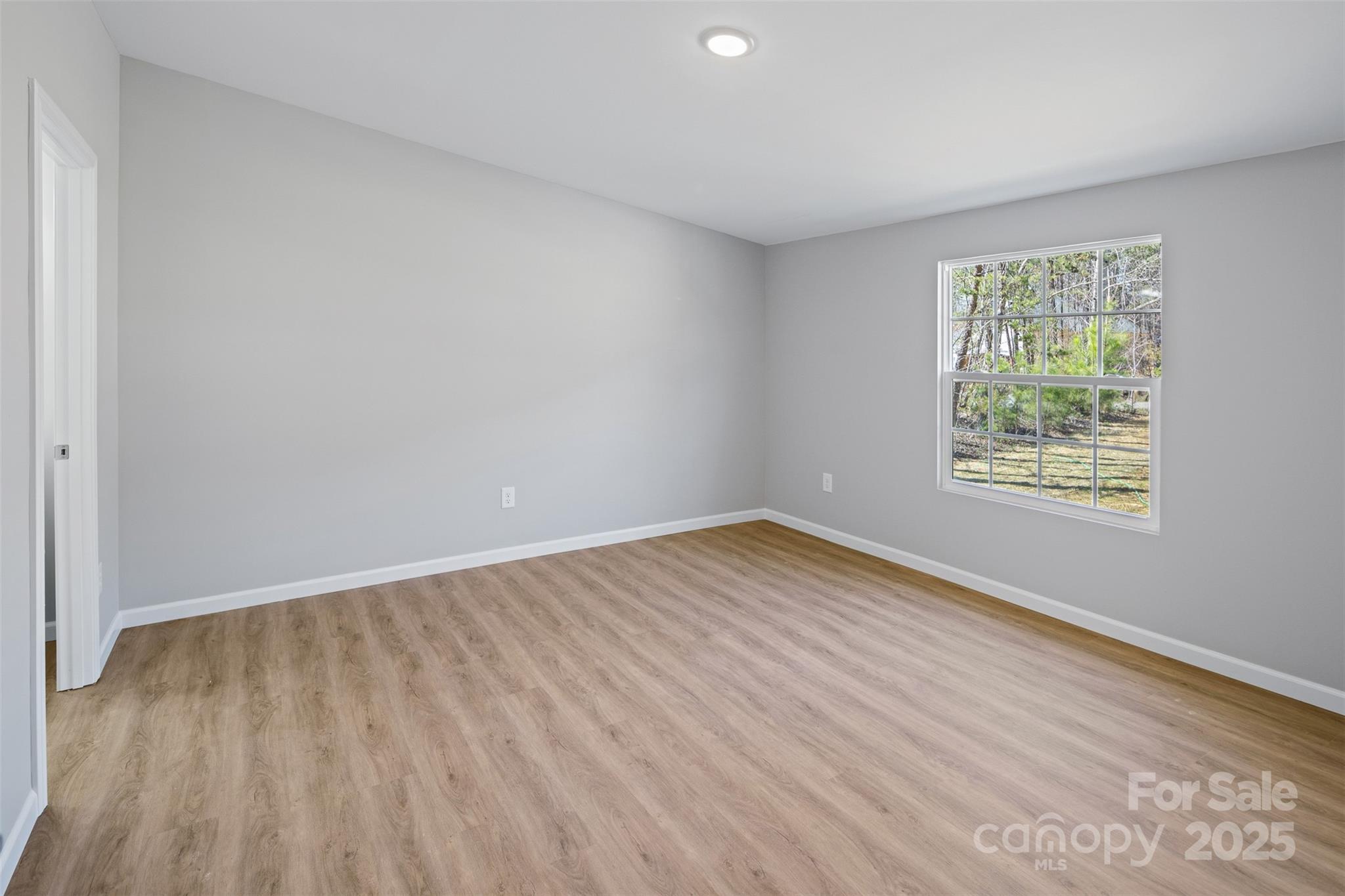 166 Brook Creek Drive Troutman, NC 28166 - Photo 17 of 26 an empty room with wooden floor and windows