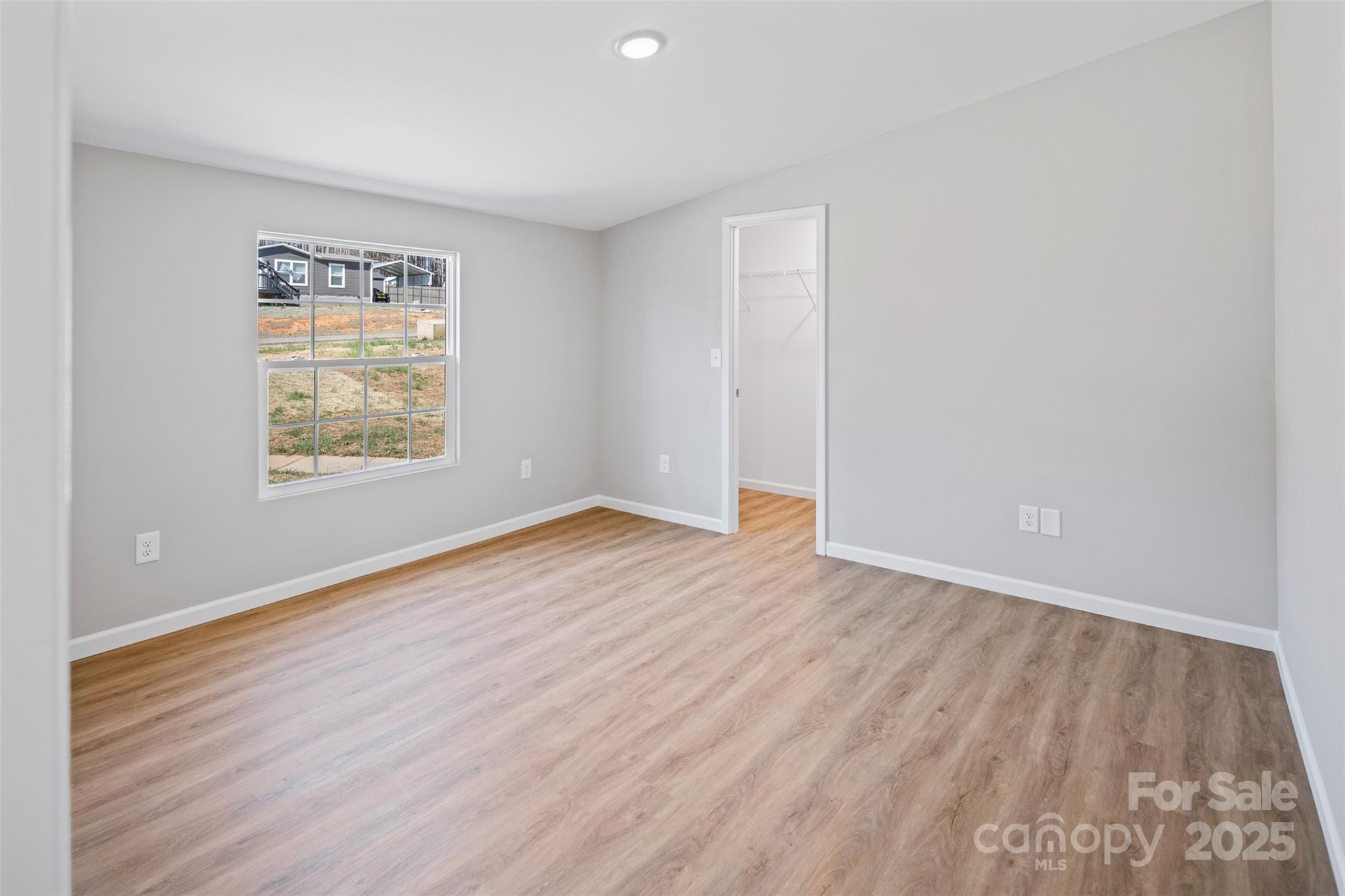 166 Brook Creek Drive Troutman, NC 28166 - Photo 18 of 26 an empty room with wooden floor and windows