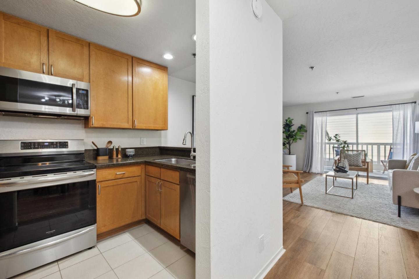 300 Murchison Drive, Unit 123 Millbrae, CA 94030 - Photo 7 of 25 a kitchen with stainless steel appliances granite countertop a stove a sink and a microwave